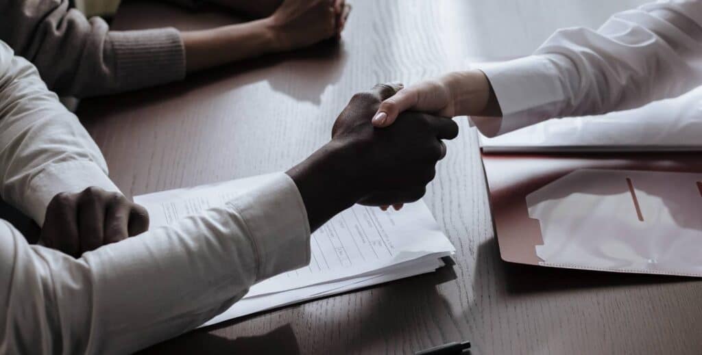 Employer and employee shaking hands in satisfaction