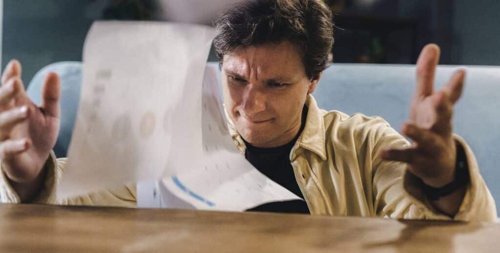 An angry man throwing paperworks away.